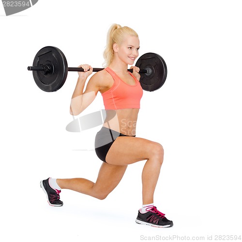 Image of smiling sporty woman exercising with barbell