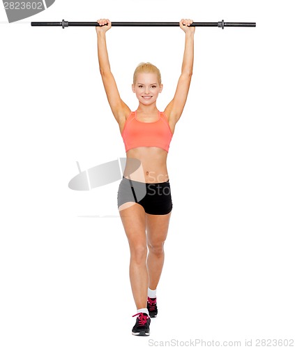 Image of smiling sporty woman exercising with barbell