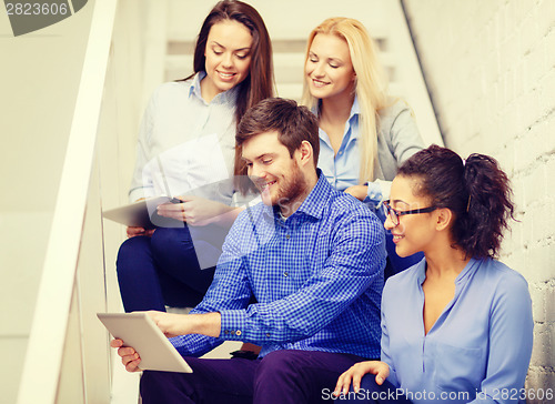 Image of team with tablet pc computer sitting on staircase