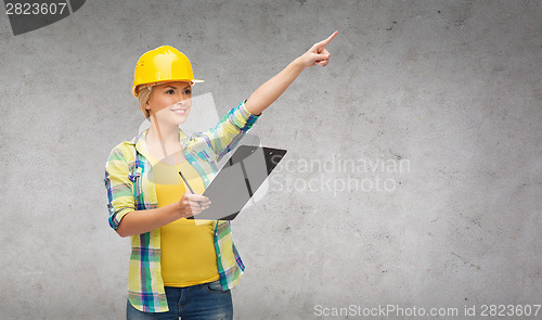 Image of smiling woman in helmet with clipboard