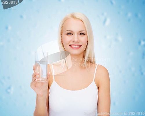 Image of young smiling woman with glass of water