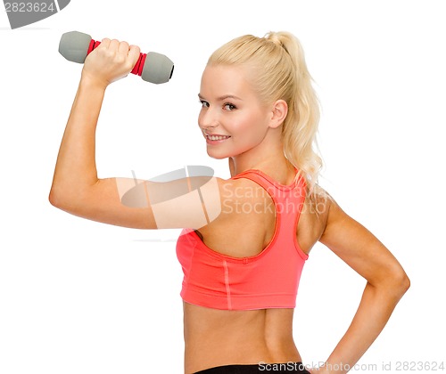 Image of young sporty woman with light dumbbell