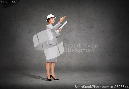 Image of smiling architect in helmet with blueprint