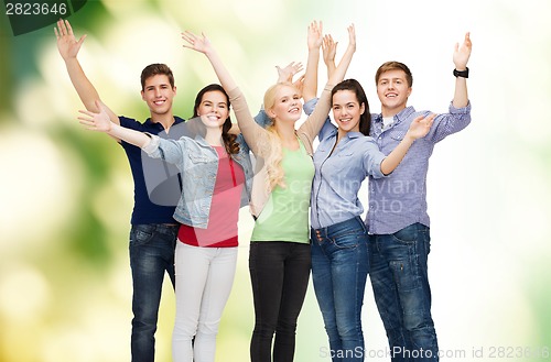 Image of group of smiling students waving hands