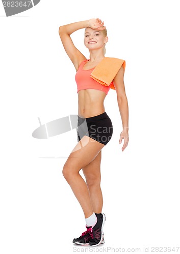 Image of smiling sporty woman with towel wiping of sweat