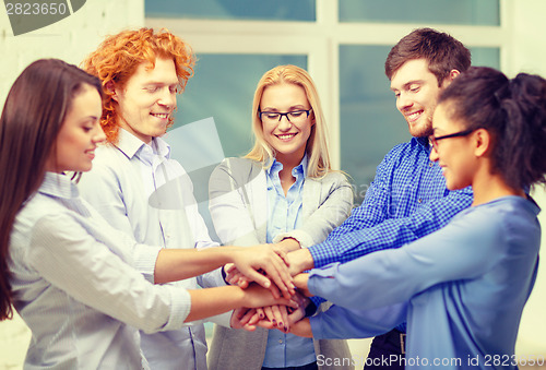 Image of team with hands on top of each other in office