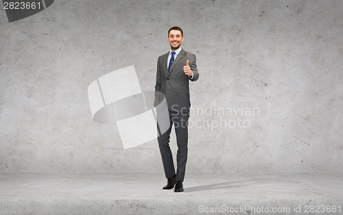 Image of handsome businessman showing thumbs up