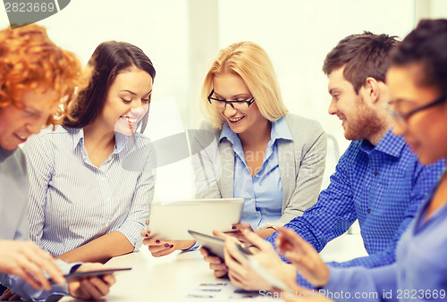 Image of smiling team with table pc and papers working