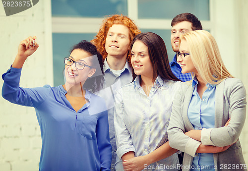 Image of smiling creative team writing on virtual screen