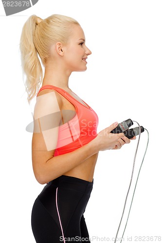 Image of smiling sporty woman with with skipping rope