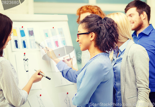 Image of designers choosing clothes designes at office