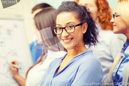 Image of smiling businesswoman with team team on the back