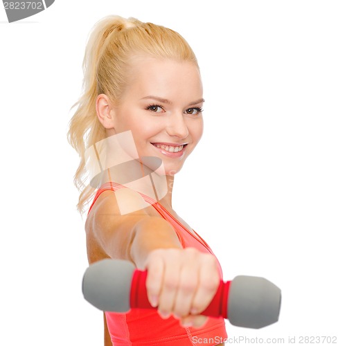 Image of smiling beautiful sporty woman with dumbbell