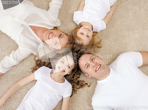 Image of parents and two girls lying on floor at home