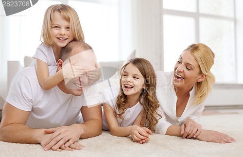 Image of parents and two girls lying on floor at home