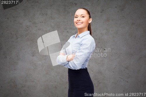 Image of young smiling businesswoman with crossed arms