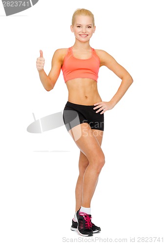 Image of beautiful athletic woman showing thumbs up