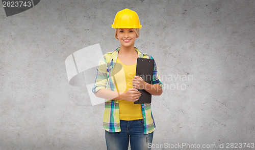 Image of smiling woman in helmet with clipboard