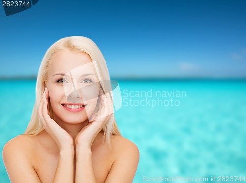 Image of face of beautiful woman touching her face skin