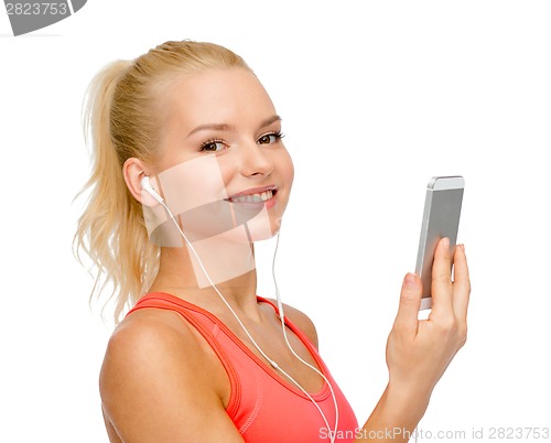 Image of smiling sporty woman with smartphone and earphones