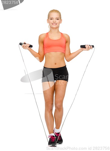 Image of smiling sporty woman with with skipping rope