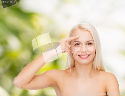 Image of beautiful woman touching her forehead