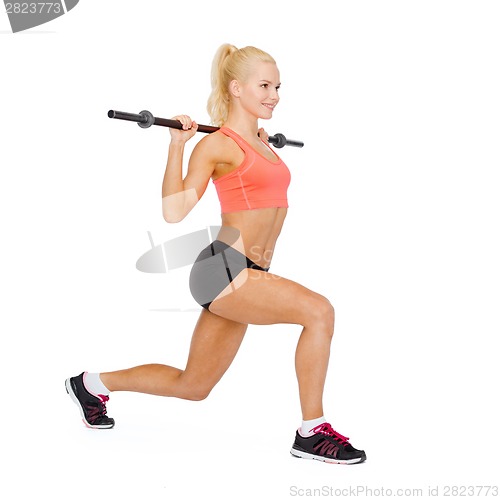 Image of smiling sporty woman exercising with barbell