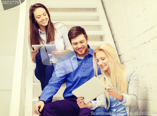 Image of team with tablet pc computer sitting on staircase