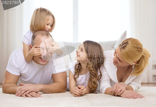 Image of parents and two girls lying on floor at home