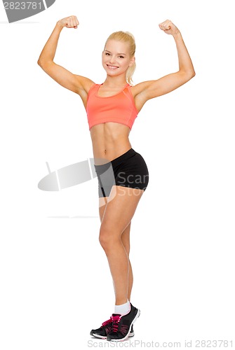 Image of smiling sporty woman flexing her biceps