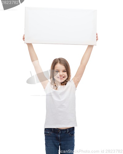 Image of smiling little child holding blank white board