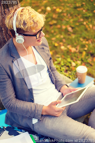 Image of smiling male student in eyeglasses with tablet pc