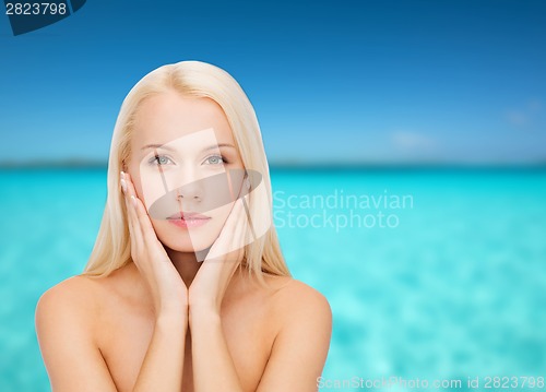 Image of face of beautiful woman touching her face skin