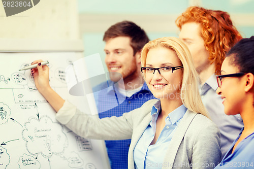 Image of smiling businesswoman with team team on the back