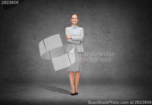 Image of young smiling businesswoman with crossed arms