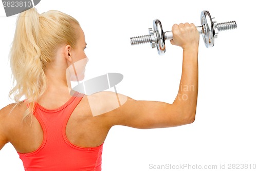 Image of sporty woman with heavy steel dumbbell from back