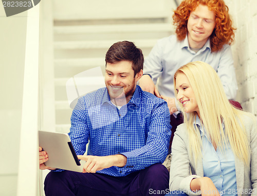 Image of team with tablet pc computer sitting on staircase