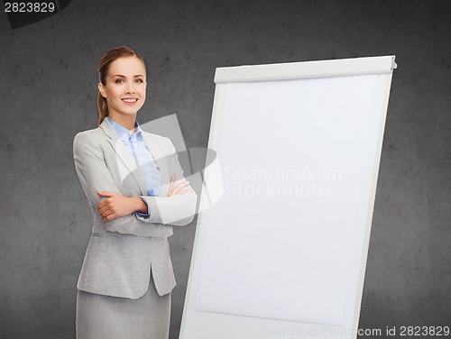 Image of smiling businesswoman standing next to flipboard