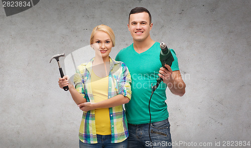 Image of smiling couple with hammer and drill