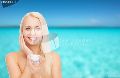 Image of woman applying cream on her skin