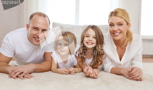 Image of parents and two girls lying on floor at home