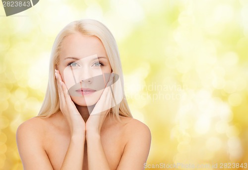 Image of face of beautiful woman touching her face skin