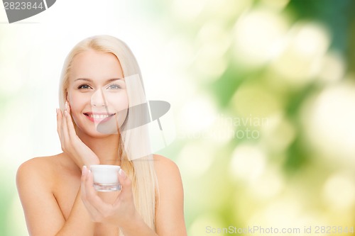 Image of woman applying cream on her skin