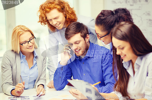 Image of creative team with papers and clipboard at office