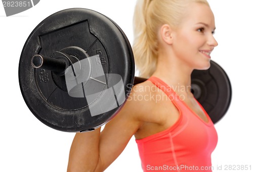 Image of smiling sporty woman exercising with barbell