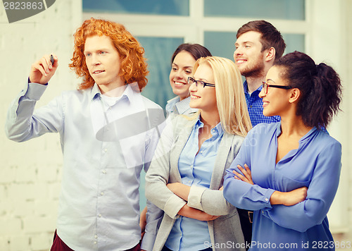 Image of smiling creative team writing on virtual screen