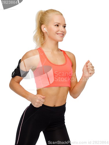 Image of sporty woman running with smartphone and earphones