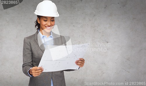 Image of businesswoman in white helmet with blueprint