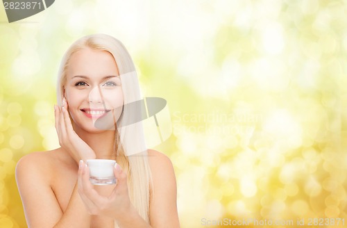 Image of woman applying cream on her skin
