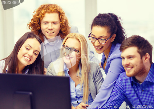 Image of smiling business team looking at computer monitor